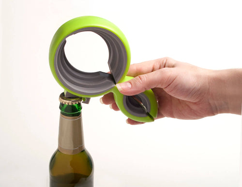 Hand using a green and gray bottle opener on a white background