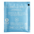 The back of a single bag of Jasmine green tea by Harney & Sons in a soft blue color on a white background.