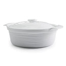 A white porcelain casserole dish with a lid on a white background.