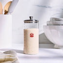 Glass container filled with sourdough and red logo on a marble surface