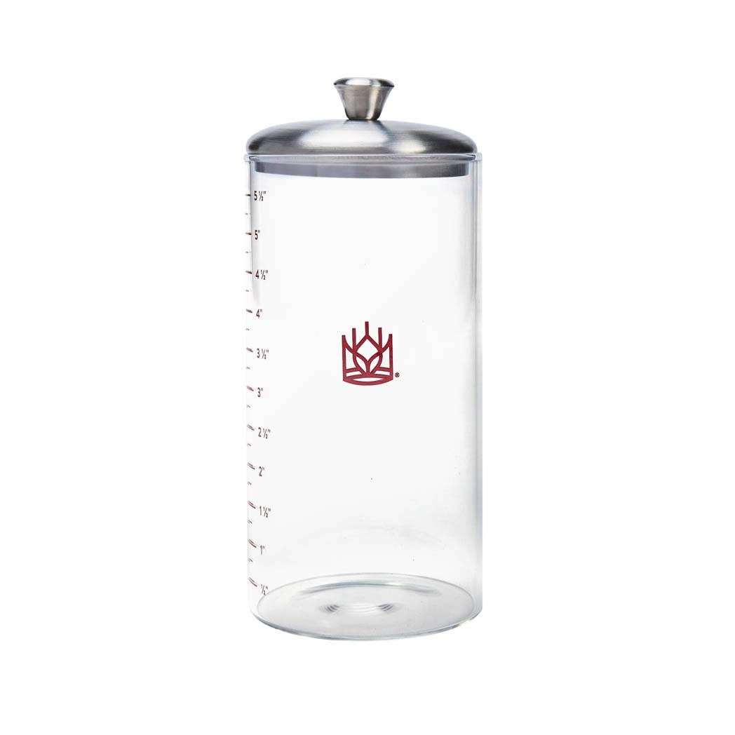 Clear glass container with silver lid and red logo on a white background