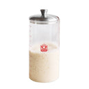 Clear container with a metal lid filled with sourdough on a white background