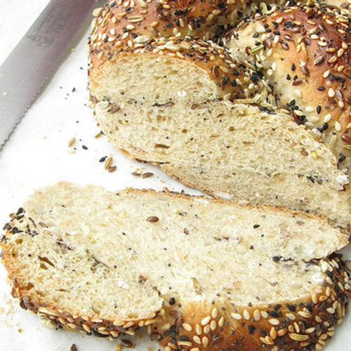 Sliced bread with sesame seeds on a white surface