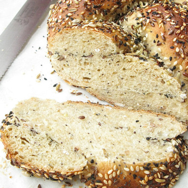 Sliced bread with sesame seeds on a white surface