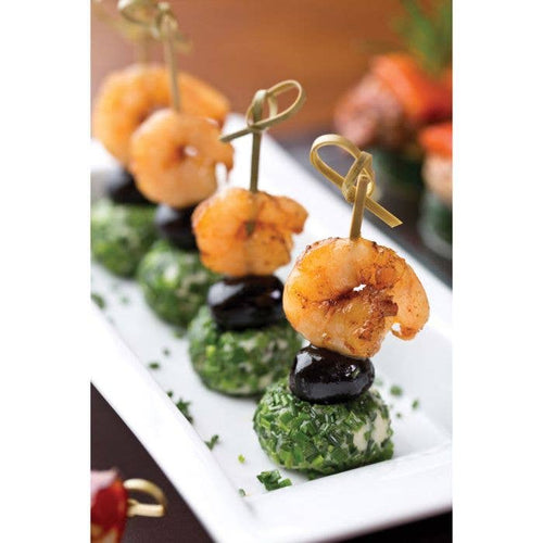 Platter of appetizers with shrimp and spinach balls on skewers.