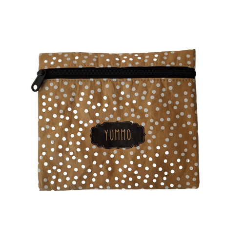 A brown paper pouch with white polka dots, featuring a black zipper and a black label in the center that reads 'YUMMO'.