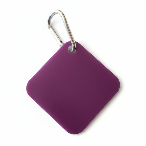 Purple square keychain with a metal carabiner on a light beige background