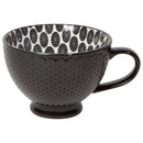A black porcelain latte mug with a dotted pattern on the inside and a solid black color in a mini honeycomb pattern on the outside.