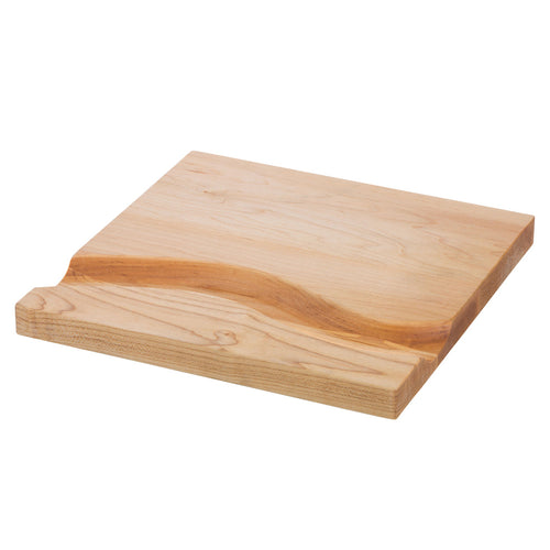 Wooden cutting board with a curved groove carved out of it on a white background