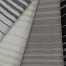 Close-up of various striped fabric patterns including black and white, green and white, gray and white.