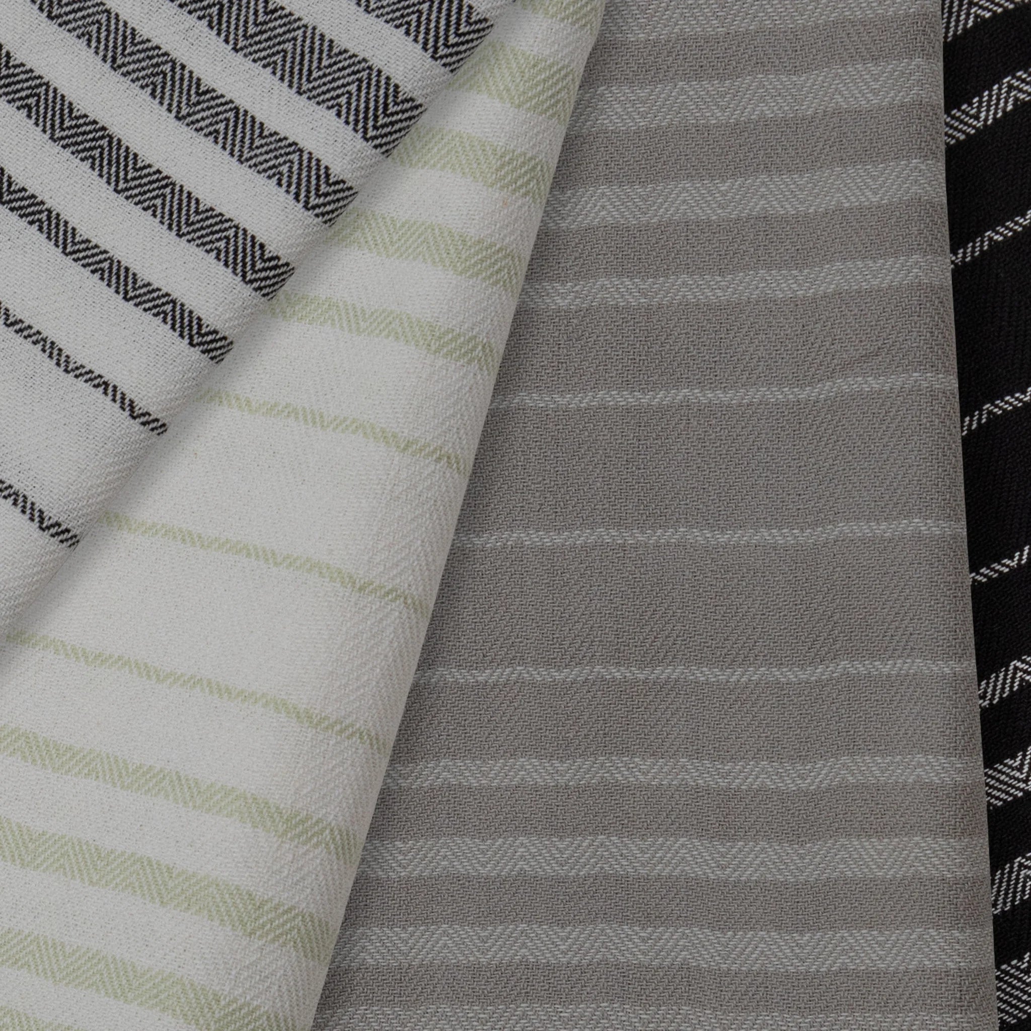 Close-up of various striped fabric patterns including black and white, green and white, gray and white.