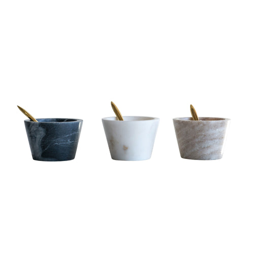 Three marble bowls with spoons on a white background.