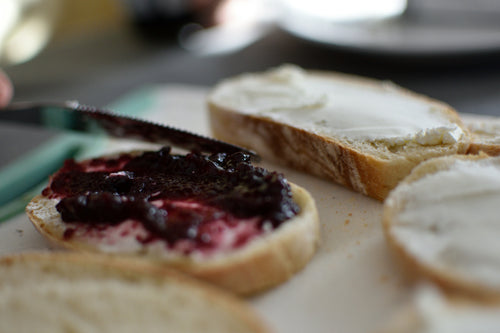 Close-up of bread slices with jelly and cream cheese on a blurred background