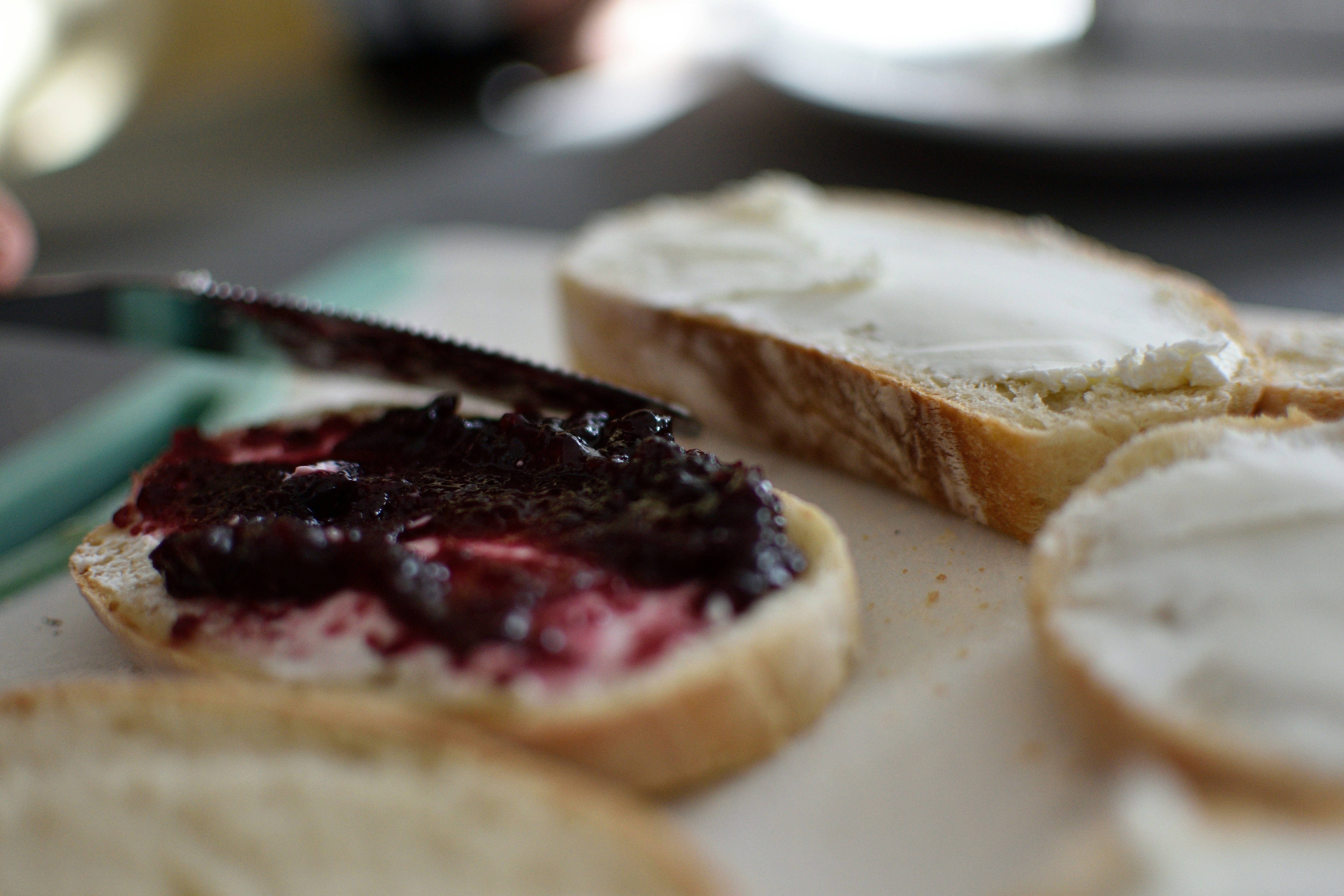 Close-up of bread slices with jelly and cream cheese on a blurred background