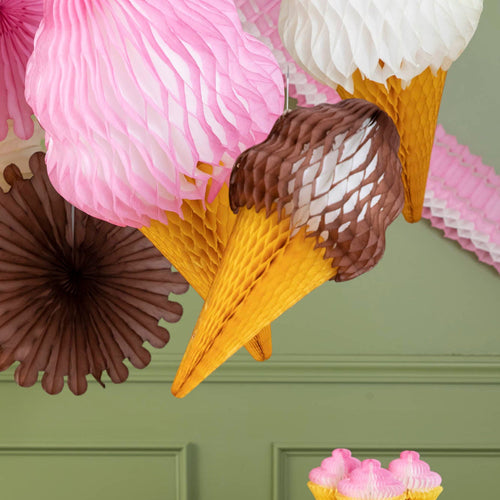 Decorative ice cream cone and flower decorations on a green wall.