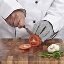 Chef cutting tomatoes on a wooden board with protective glove