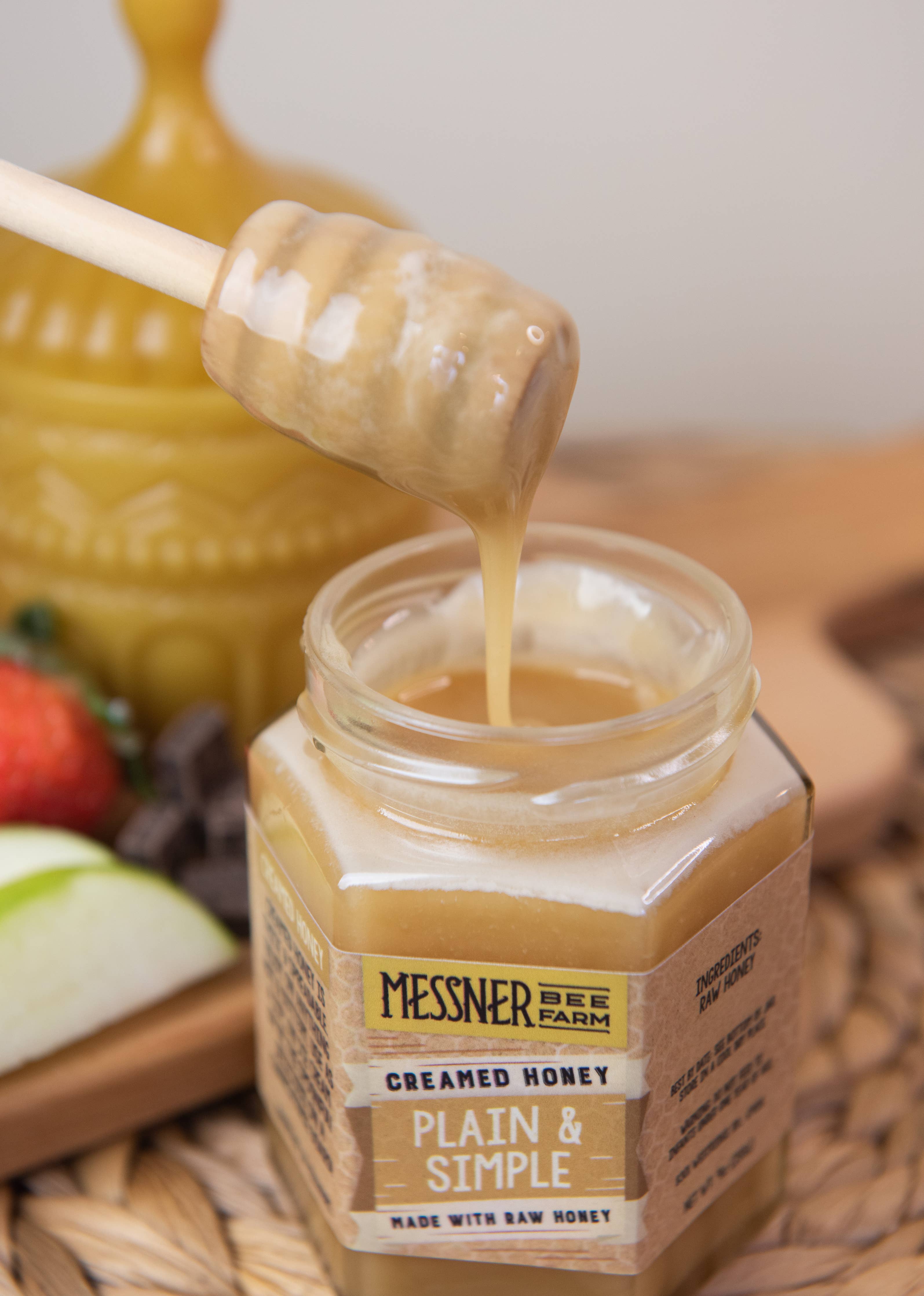 Jar of Messner Bee Farm creamed honey with a honey dipper