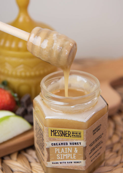 Jar of Messner Bee Farm creamed honey with a honey dipper