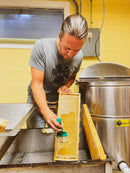 Person cleaning honeycomb frames in a kitchen setting
