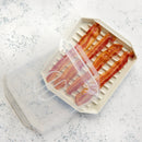 Bacon slices in a clear plastic container on a speckled countertop