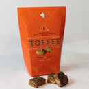 Orange toffee packaging with three pieces of toffee on a white background