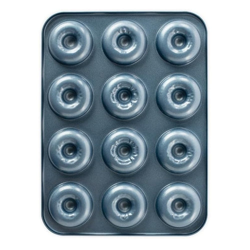Metal donut baking tray with twelve evenly spaced donut shapes on a white background