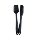 Two black silicone spatulas with metal cores and holes in the handles for hanging, displayed against a white background.