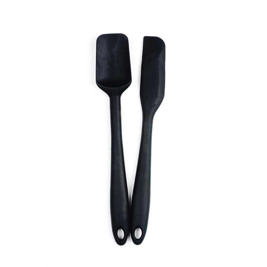 Two black silicone spatulas with metal cores and holes in the handles for hanging, displayed against a white background.