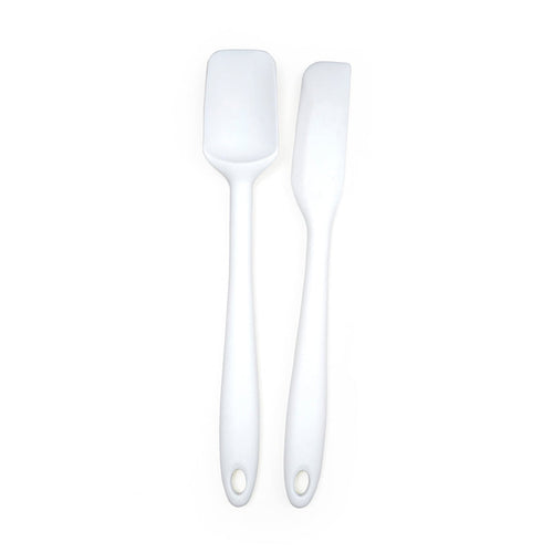 Two white silicone spatulas with metal cores and holes in the handles for hanging, displayed against a white background.