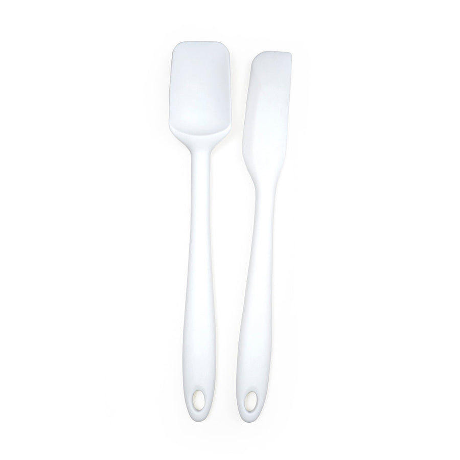 Two white silicone spatulas with metal cores and holes in the handles for hanging, displayed against a white background.