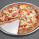 A round pizza with a slice removed, topped with melted white cheese, red tomatoes, orange peppers, and green onions, served on a silver metal pan against a dark gray background.