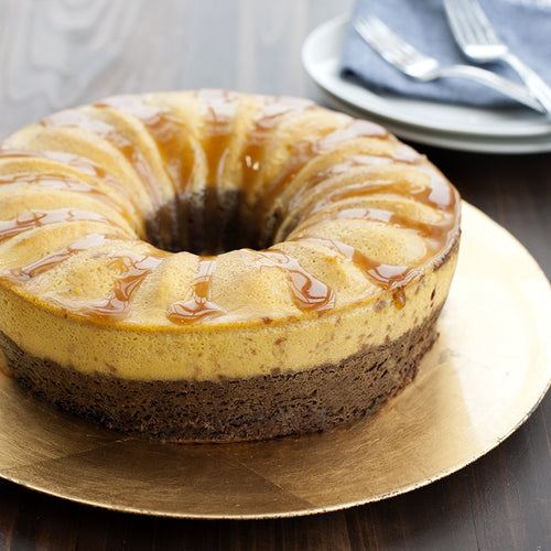 Bundt cake with caramel drizzle on a gold plate with a blurred background