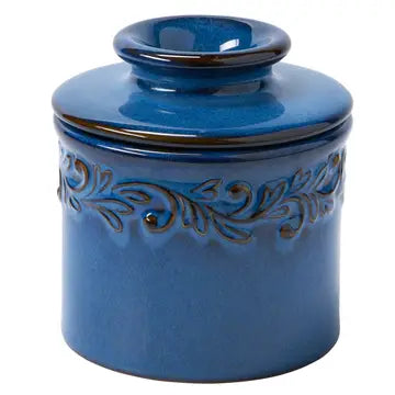 A blue ceramic Butter Bell crock with intricate leaf embossing.