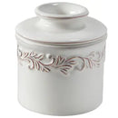 A white ceramic Butter Bell crock with intricate leaf embossing.