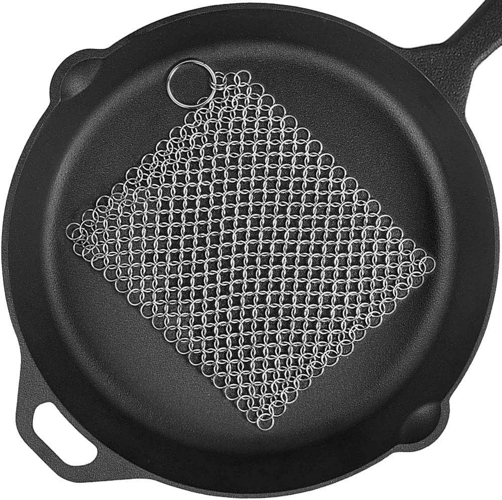 Cast iron skillet with a metal scrubber on a white background