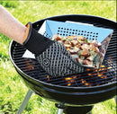 Person using a grill glove to handle food on a barbecue grill outdoors.