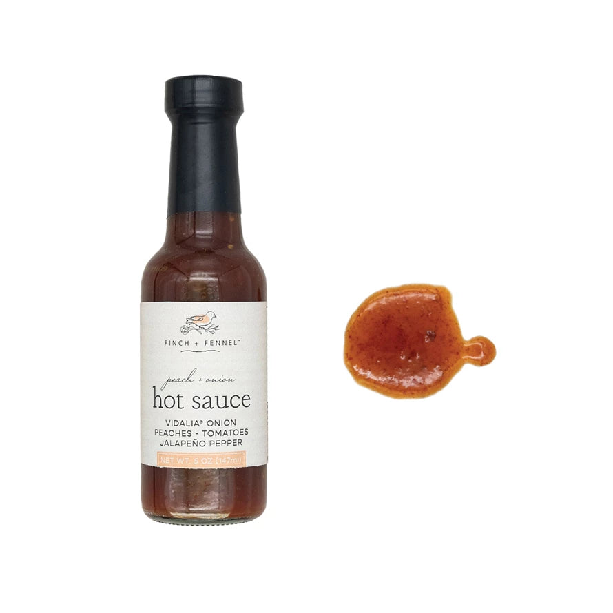 Bottle of hot sauce with a small sample on a white background