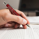 Red pen with a logo held by a hand on lined paper