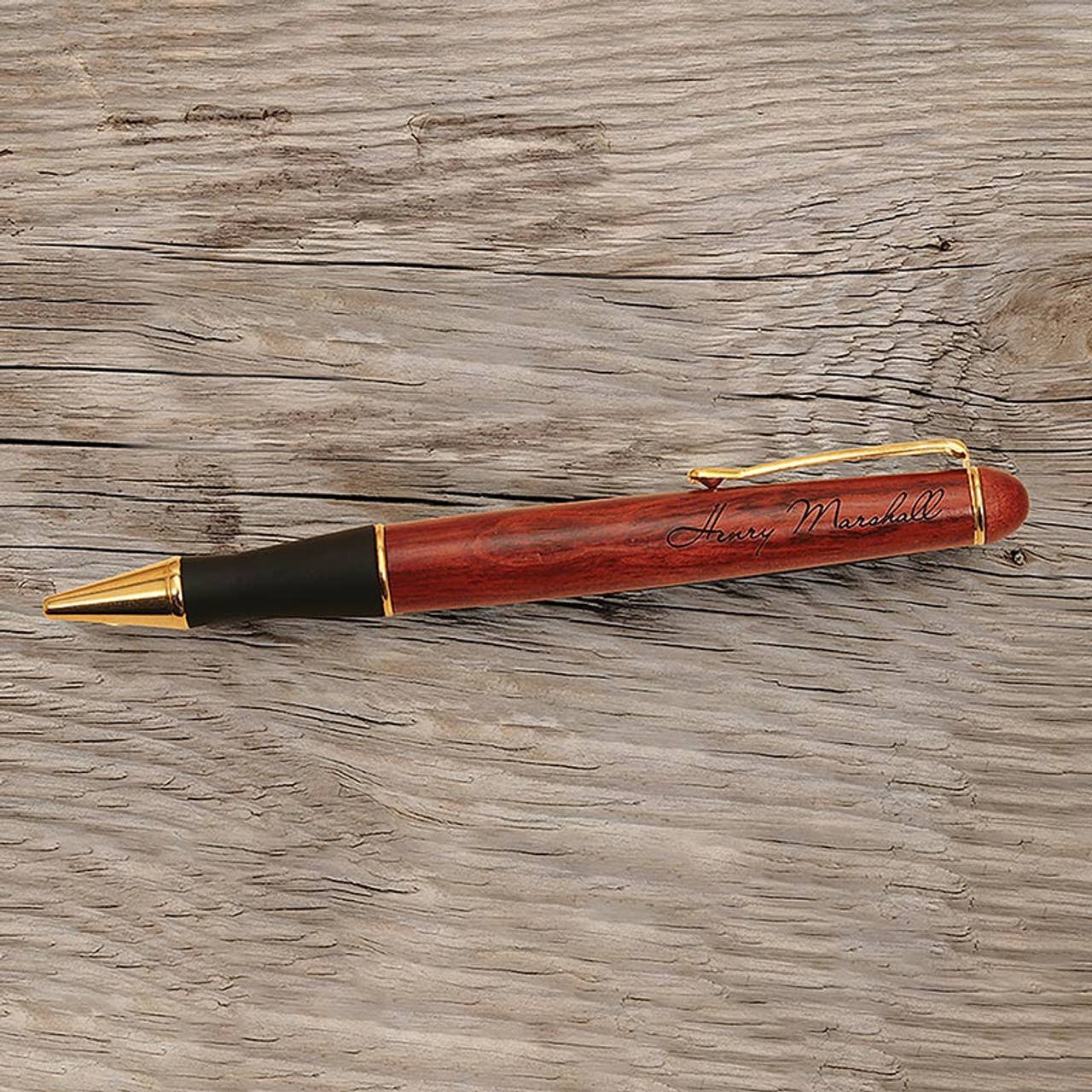 Wooden pen with gold accents on a wooden surface