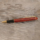 Wooden pen with gold accents on a wooden surface