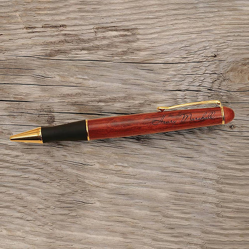 Wooden pen with gold accents on a wooden surface