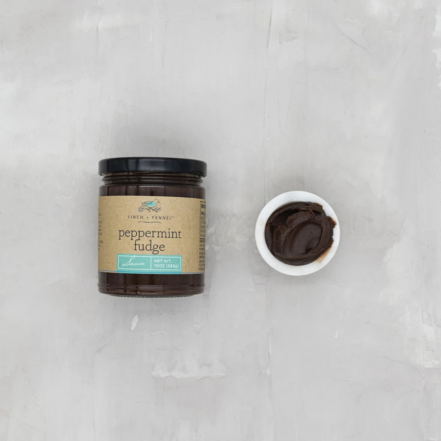 Jar of peppermint fudge with a small bowl of fudge on a gray background