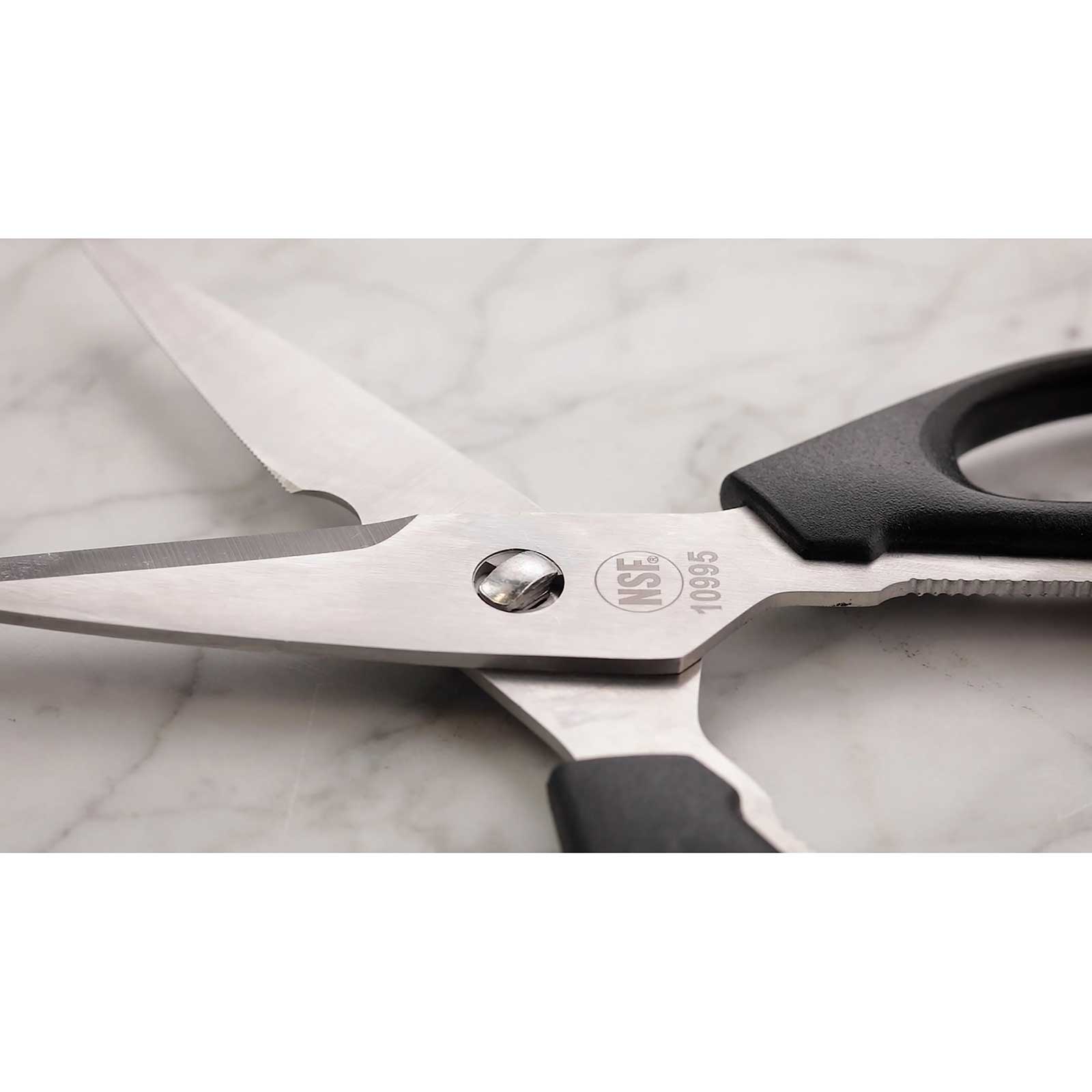 Pair of scissors with black handles on a marble surface