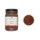 Jar of pizza sauce with a label and a close-up of the sauce on a white background