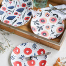 Floral-patterned plates on a wooden tray with utensils.