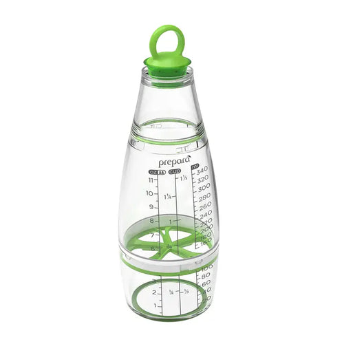 Clear measuring dressing shaker with green lid and measurement markings on a white background