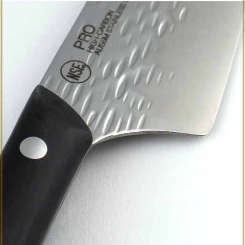 A close-up of a kitchen knife with a hammered silver blade and a black handle, shown on a white background.