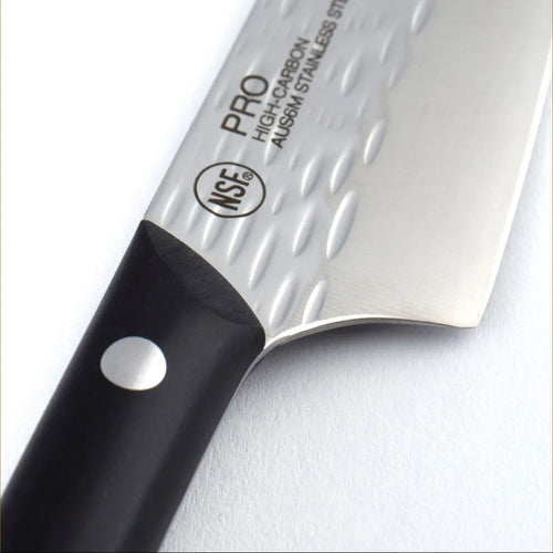 A close-up of a kitchen knife with a textured silver stainless steel blade and a black handle, featuring the NSE PRO logo and AUSM stainless steel text on the blade.
