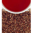 A closeup of dried raspberry tea and a cup of raspberry tea on a white background.