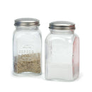 A salt and pepper shaker set filled partway with pepper and salt on a white background.